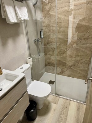 A modern bathroom with a glass-enclosed shower, a toilet, and a sink. - Hostal Fernández Atocha (Madrid)