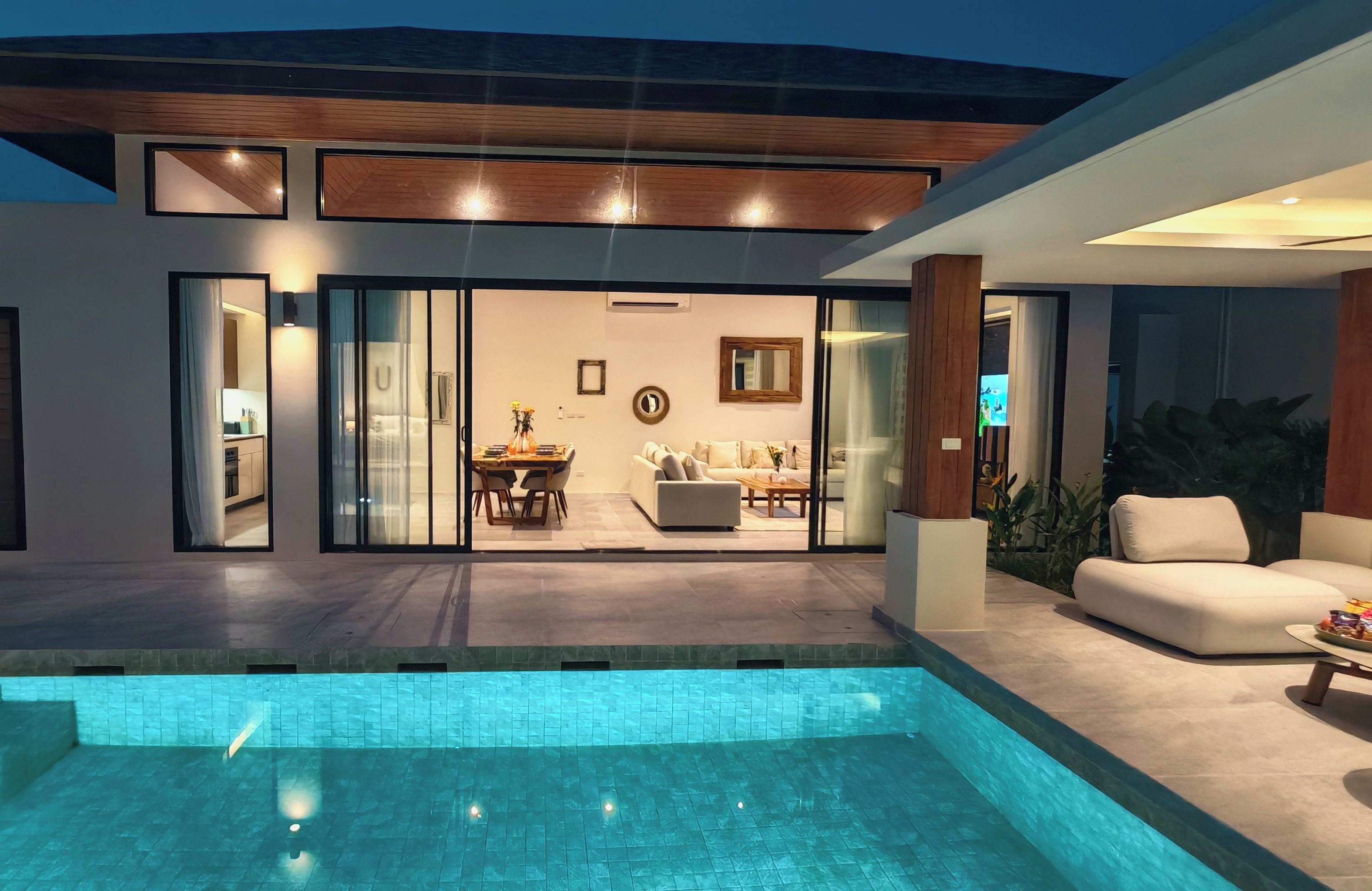 Une maison moderne dotée d’une piscine, d’un coin repas et d’un salon.