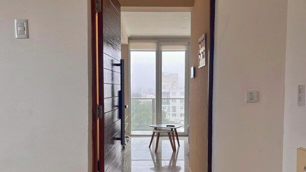 Un pasillo que conduce a un balcón con vistas a edificios.