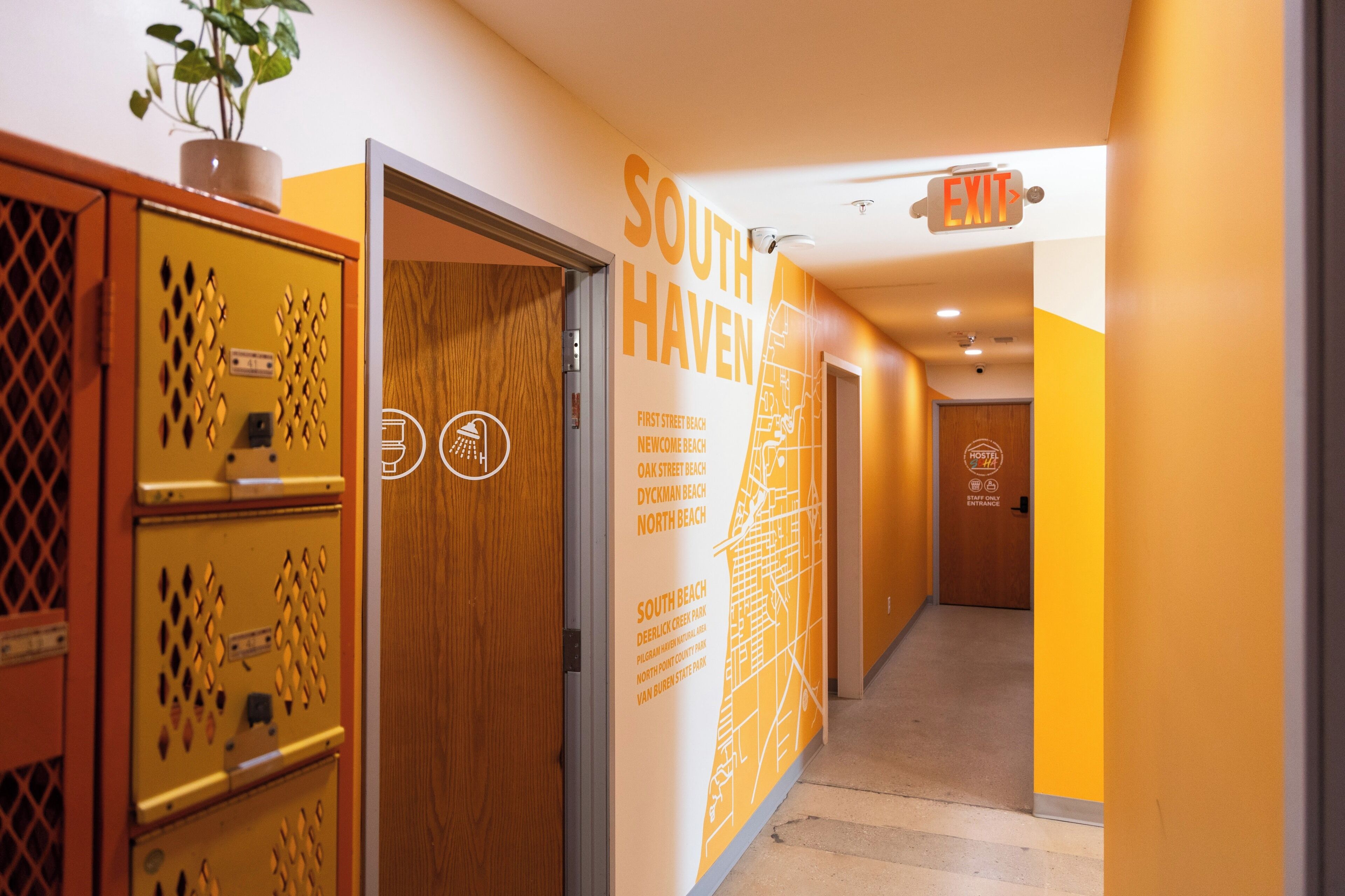 Un pasillo de hotel con un mapa de South Haven, una puerta de madera y una señal de salida.