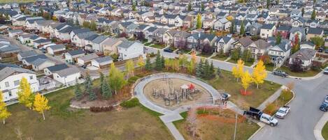 A residential area with houses, a playground, and a road.