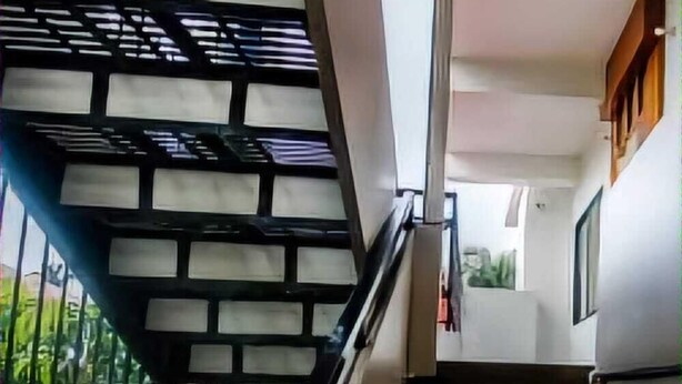 A staircase with a handrail and a view of the outside.