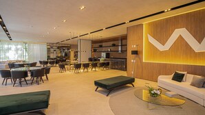 A modern interior with a dining area, a sofa, and a coffee table. - Sunset Rooftop Studio - Comfort & Modernity in Brooklyn (Jardim das Acacias São Paulo)
