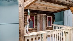 Eine rustikale Holzhütte mit Holzbalkon und einer Tür, die mit Geweihen verziert ist.