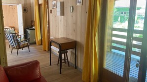 A wooden interior with a dining area, a red sofa, and a window with yellow curtains. - The Kingfisher (Autrey)