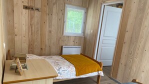 A small, cozy room with a bed, a desk, and a window. - The Kingfisher (Autrey)