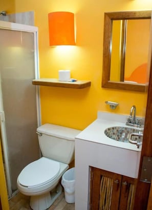 Een aparte badkuip en douche, handdoeken, zeep, toiletpapier
