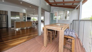 A spacious kitchen with modern appliances, a wooden dining table, and a seating area with cushions.