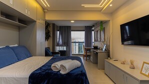 Ein modernes Hotelzimmer mit Bett, Schreibtisch und Fernseher.