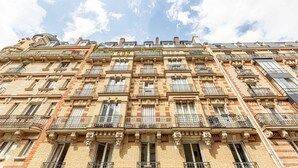 A multi-story building with a classic architectural style, featuring numerous balconies and windows.