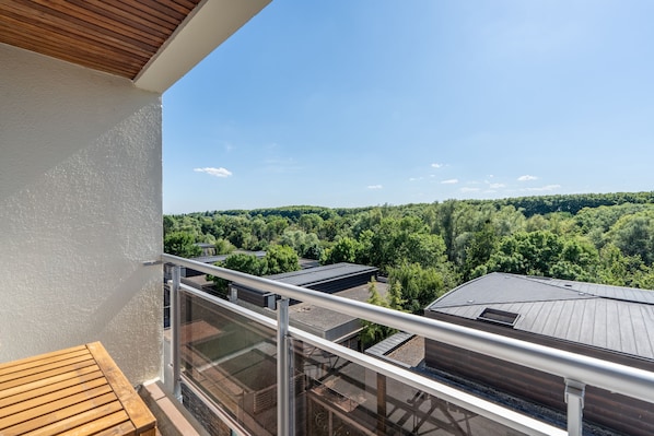 A balcony with a view of a forested landscape.