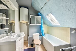 A modern bathroom with a bathtub, toilet, and sink. - Le Nid Marin - A 400m de la plage (Saint-Aubin-sur-Mer)