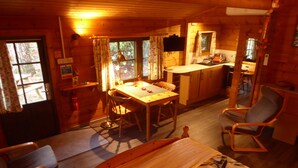 Un accogliente chalet con zona pranzo, cucina e soggiorno.