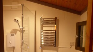 Un bagno con doccia vetrata, un water e un lavandino.
