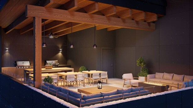 Een terras met houten tafels en stoelen, een bank en een vuurplaats.