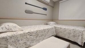 Une pièce avec deux lits, un banc, une pagaie fixée au mur et un appareil de climatisation.