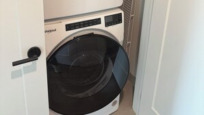 A compact, white Whirlpool washer and dryer unit installed in a narrow hallway. - 3Bed3.5Bath @ Burk’s Falls's View (Burk's Falls)