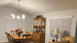 A dining area with a wooden table and chairs, a cabinet with glass doors, a flower-patterned coffee table, and a leather sofa. - Karen’s Cove
Charming 2-bedroom house in terrific Darien with WiFi, AC (Darien)