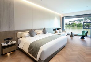 A modern hotel room with a large bed, bedside tables, a small table, and a chair. - Wyndham Garden Liuzhou Wuxing Street (Liuzhou)