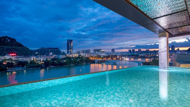 An infinity pool with a cityscape view, a glass ceiling, and a modern architectural design. - Wyndham Garden Liuzhou Wuxing Street (Liuzhou)