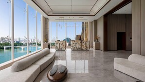 A spacious living area with a large window overlooking a river and cityscape, a modern sofa, and a unique coffee table. - Wyndham Garden Liuzhou Wuxing Street (Liuzhou)