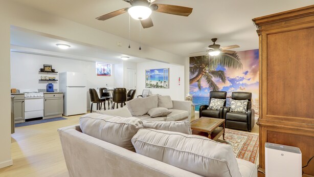 A spacious living area with a sofa, a dining table, and a kitchen in the background. - 5 Mi to Trilith Studios: Apt w/ Furnished Pergola (Fayetteville)