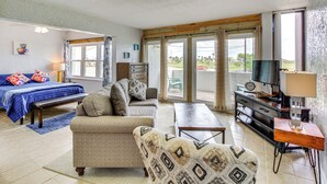 A spacious living room with a sofa, a coffee table, a TV, and a wooden cabinet. - Swim, Fish & Suntan: Cozy Corpus Christi Retreat (Corpus Christi)