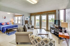 A spacious living room with a sofa, a coffee table, a TV, and a wooden cabinet.
