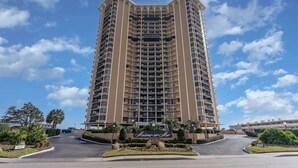 A tall, multi-story hotel with a central entrance and a sign reading "Mansion on the Bay."