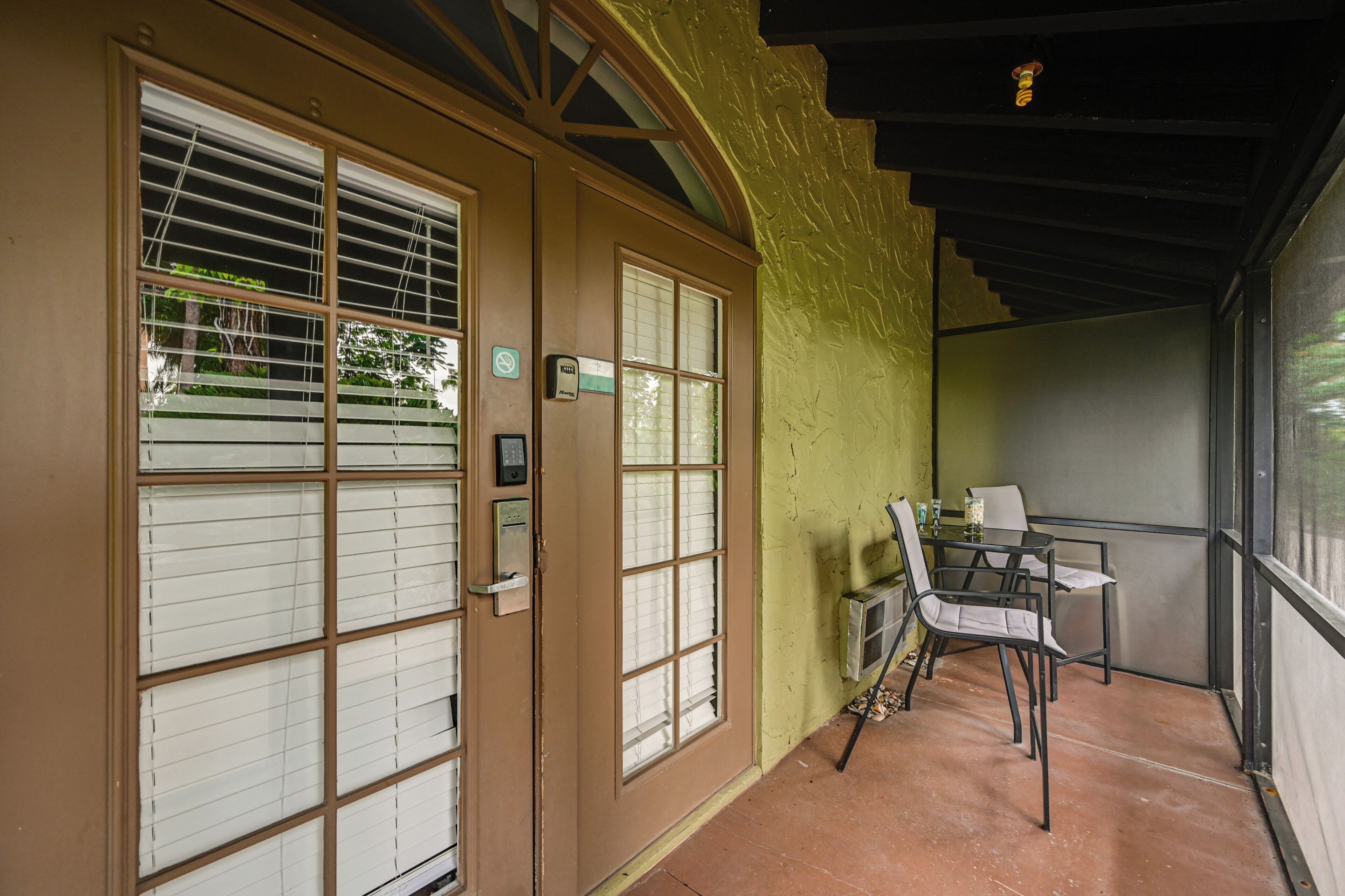 A room with a sliding door, a small table with chairs, and a view through the door.