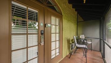 A room with a sliding door, a small table with chairs, and a view through the door.