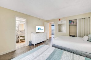 A bedroom with a bed, a dresser, a television, and a closet.