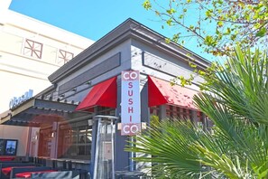 Un restaurant de sushis avec un auvent rouge et une enseigne.