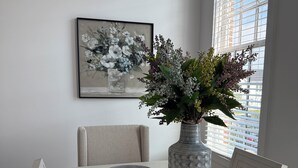 A dining table with a vase of flowers, placemats, and a framed artwork on the wall. - 3-bedroom condo in Norton Commons (Prospect)