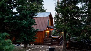 A cabin with a wooden exterior, a porch with a hot tub, surrounded by dense trees. - Strawberry Summit Cabin Retreat (Duck Creek Village)