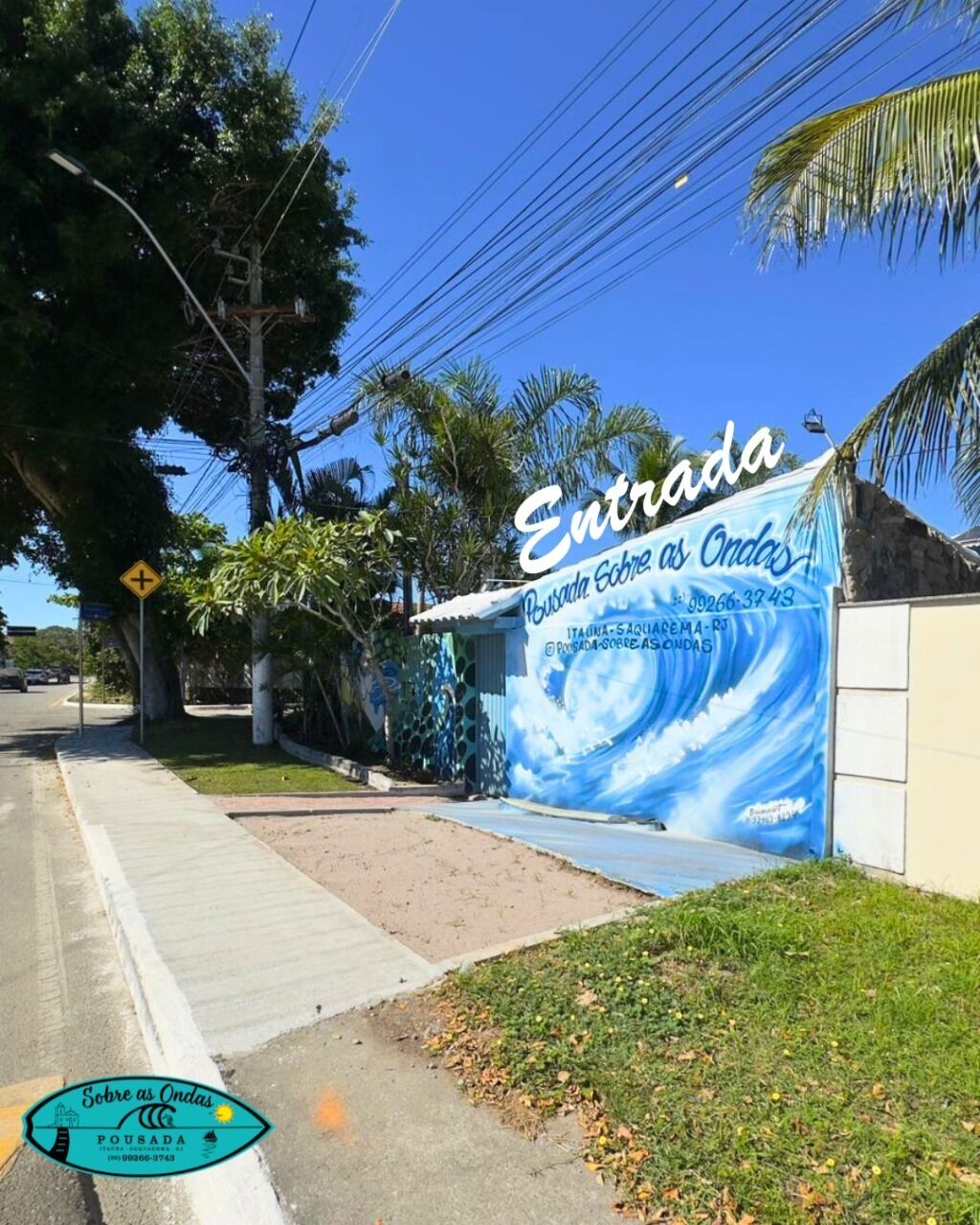 A building entrance with a sign reading "Entrada" and a mural of waves.