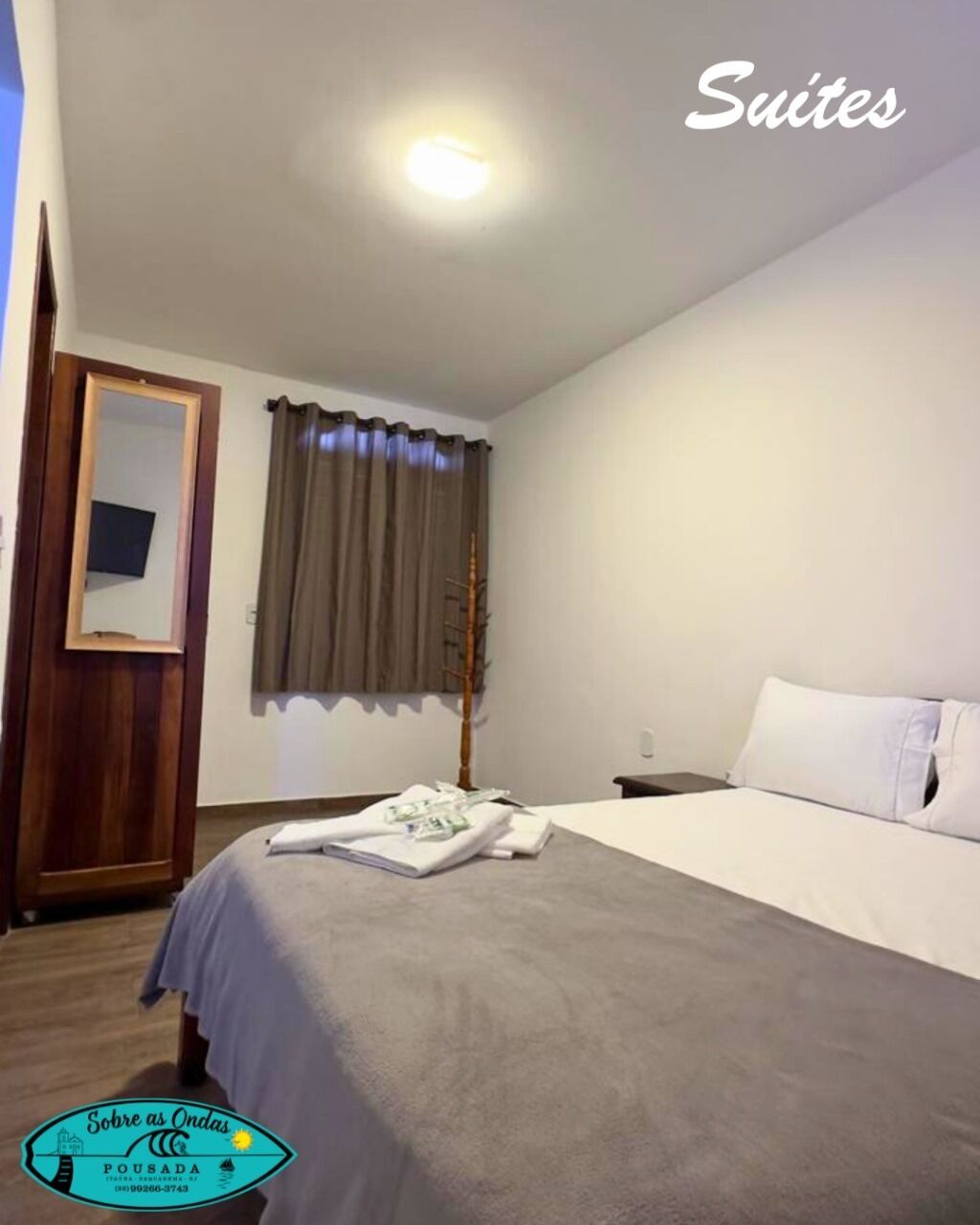 Una habitación de hotel con una cama, una mesita de noche, un espejo y una ventana con cortinas.