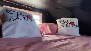 A bed with two pillows, each featuring the word "Love" and a heart symbol. - Fiat Ducato Vacation Motorhome (Chio Calle Campo Santo 43)