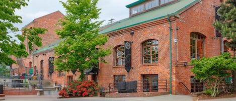 A brick building with a green roof, large windows, and a sign that reads "Entrance."
