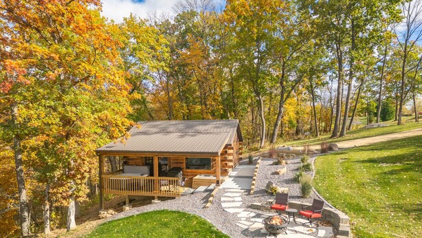 A lodge with a deck, outdoor seating, and a fire pit.