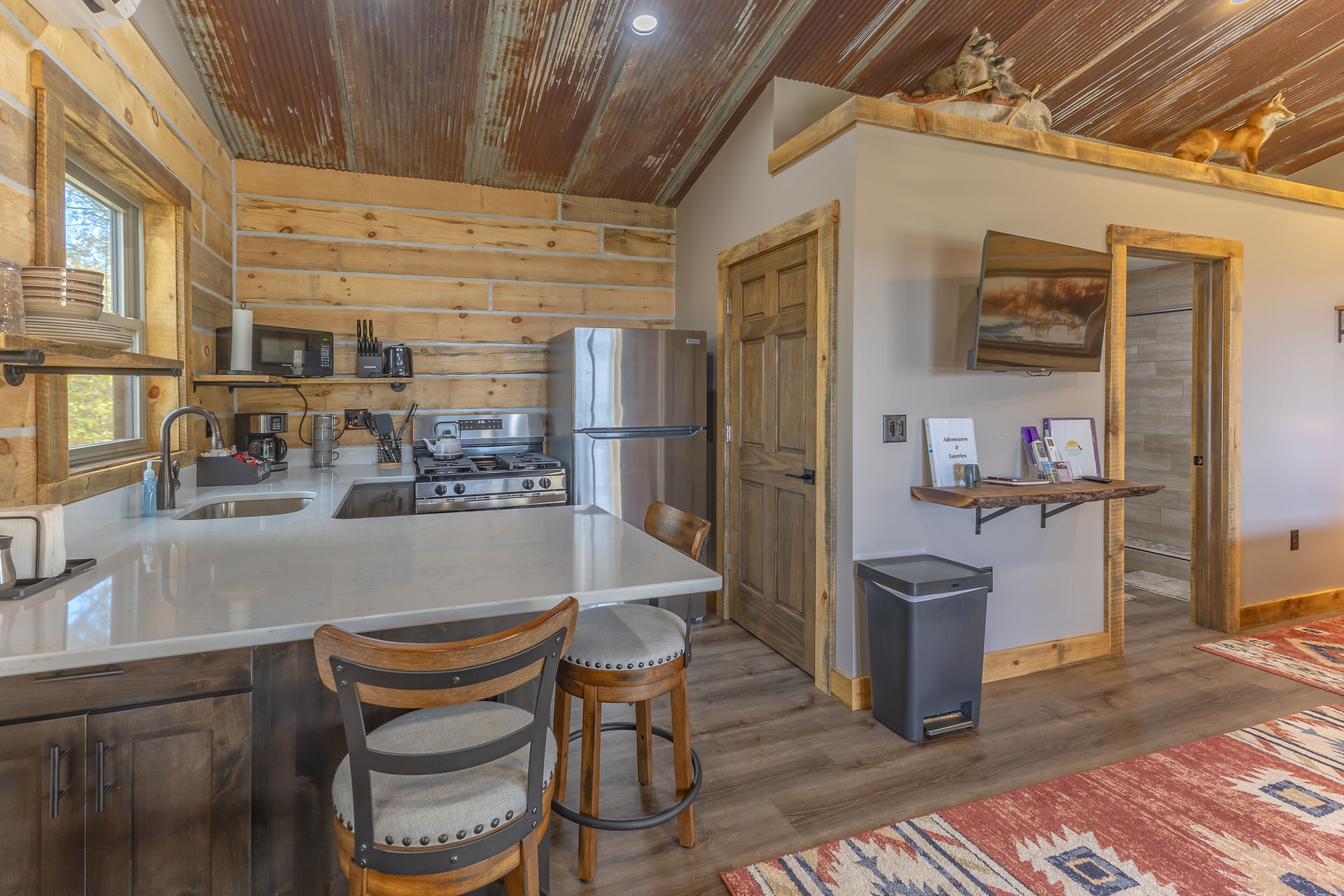 Een moderne keuken met een centraal eiland, houten kastjes en een roestvrijstalen koelkast.