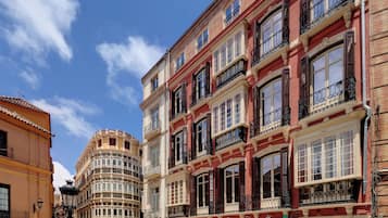 Una calle con edificios históricos, incluyendo una farmacia y una tienda con un letrero que dice 'SANTA MARIA'.