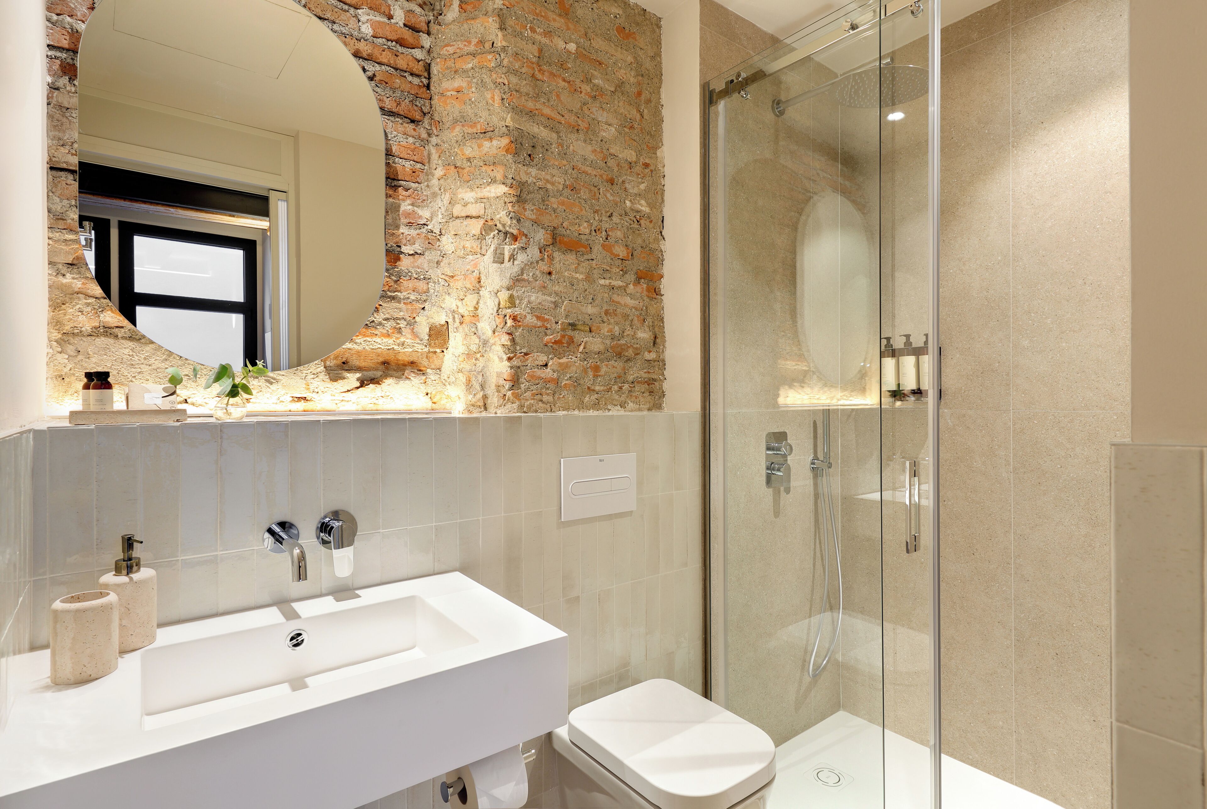 Un baño con un lavabo blanco, un inodoro y una ducha con cerramiento de vidrio.