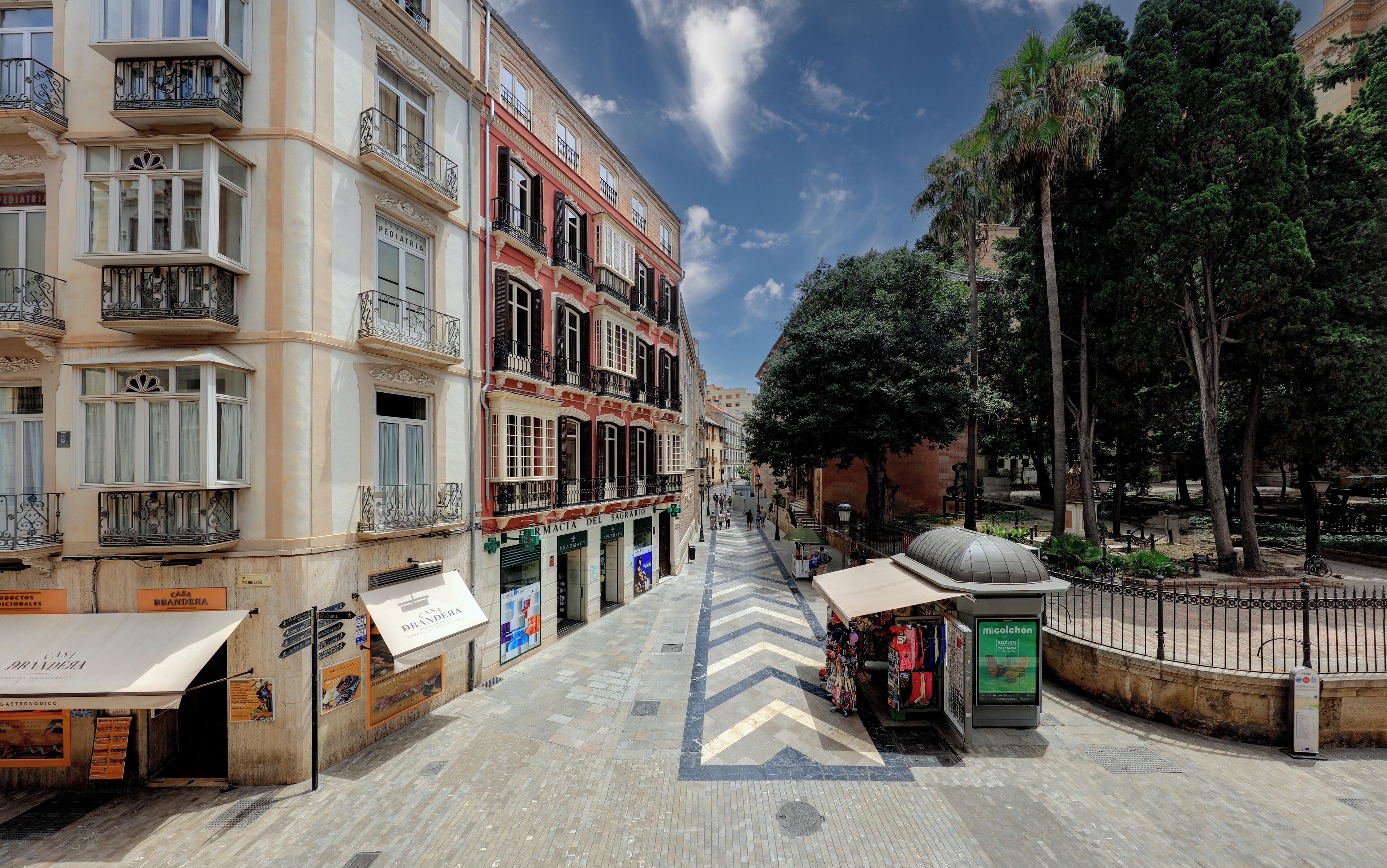 A street with buildings, a kiosk, and a fountain.