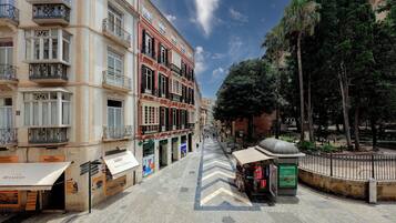 Una calle con edificios, un quiosco y una fuente.