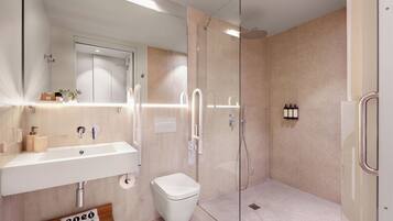 Un baño moderno con un lavamanos grande, inodoro y cabina de ducha de vidrio.