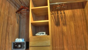 A wooden interior with a built-in microwave, a hanging clothes rack, and a shelf with a small appliance. - Oceanfront 1BR en Ultravioleta Cabarete. Wifi Rápido, Balcón & Parking (Cabarete)