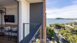 A balcony with a view of the sea and a dining area with chairs and a table. - Studios in a Seaside Building, Close to Beto Carreiro at Penha Spot - Psob (Penha)