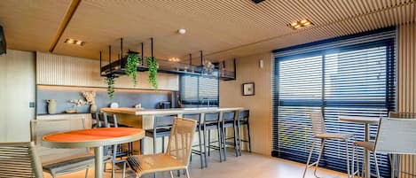 A modern interior with a kitchen, dining area, and large windows.