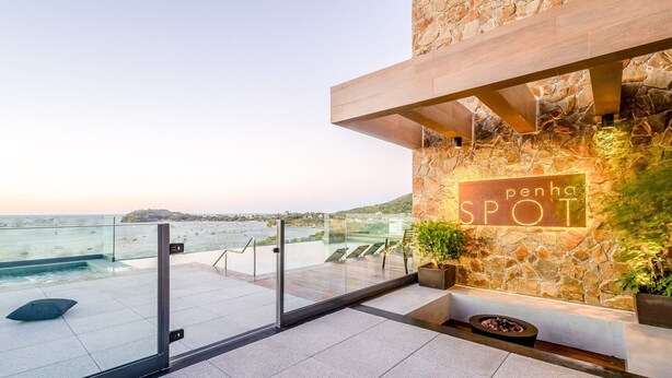 A modern building with a stone facade, a sign reading 'penha SPOT', and a view of the sea. - Studios in a Seaside Building, Close to Beto Carreiro at Penha Spot - Psob (Penha)